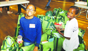 OMoxie Coleman-Miller, 10, and Alicia Gayle, 10, sort food at the All Souls Unitarian Church food drive on Nov. 22. Photo by Nancy Shia