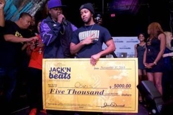 Prince George's County rap artist Osiris Green (center) is presented with a $5,000 check by rapper Jadakiss at the Blind Whino in D.C. on Nov. 5 for winning Jack Daniel's Jack'N for Beats music competition.