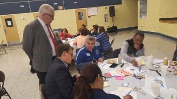 Prince George's County Public Schools CEO Kevin Maxwell (left) listens as a group discusses ways to improve transparency among school officials during a community summit at Ernest E. Just Middle School in Mitchellville on Nov. 5. /Photo by William J. Ford