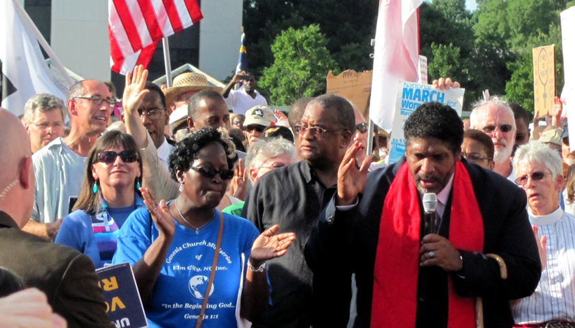 Rev. Dr. William Barber II (right), the president of the N.C. state branch of the NAACP, speaks at a Moral Mondays rally in 2013.