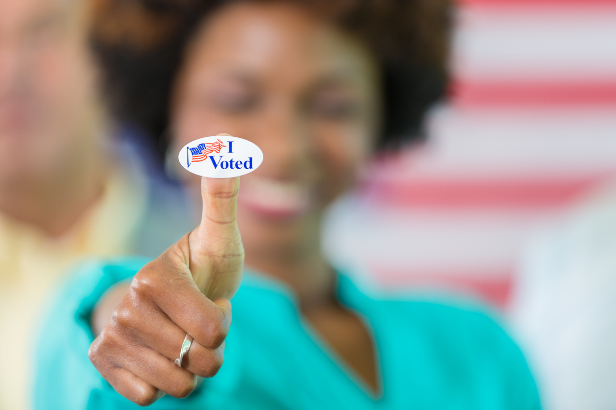 Smiling african american woman with an "I voted" sticker on her thumb. /Photo: iStock