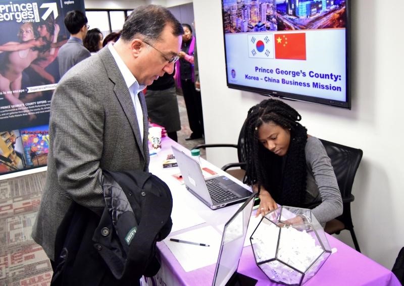 Prince George's County Economic Development Corporation Account Assistant LeSha Jean Francois checks in a business owner at an information session for an upcoming business mission trip to Korea and China. (Courtesy of PGCEDC)