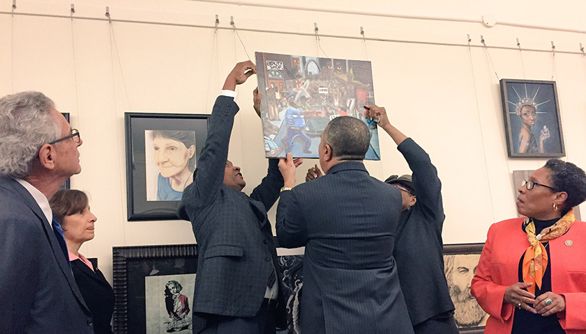 CBC members hang student’s artwork on January 10, after a Republican congressman removed it early last week. (Lauren Burke/NNPA)