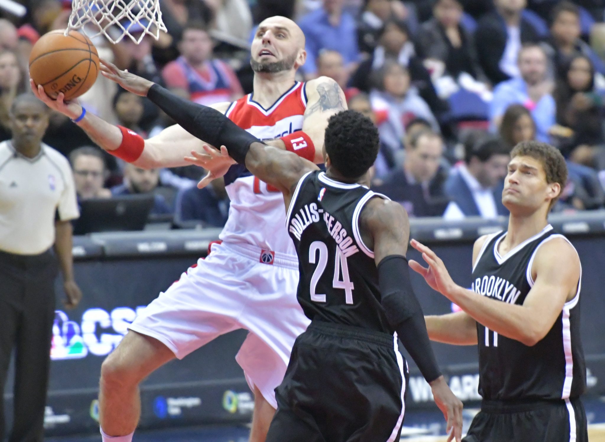 Washington Wizards center Marcin Gortat attempts a layup beyond the outstretched arm of Brooklyn Nets forward Rondae Hollis-Jefferson in the third quarter of the Wizards' 129-108 win at Verizon Center in northwest D.C. on March 24. (John De Freitas/The Washington Informer)