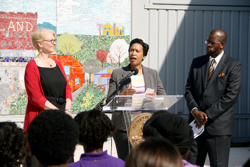 D.C. Mayor Muriel Bowser (center), with Deputy Mayor of Education Jennifer Niles (left) and DCPS Chancellor Antwan Wilson (right), announces plans to invest $6.2 million in the city's public middle and high schools during a press conference at Brookland Middle School in Northeast on Feb. 24. (Shevry Lassiter/The Washington Informer)