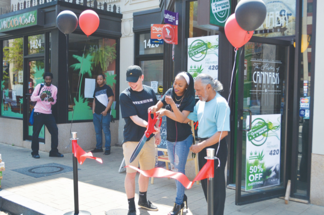 The History of Cannabis Museum staff celebrates the opening with a ribbon cutting on April 20 in Northwest. (Photo by Steve Garrett)