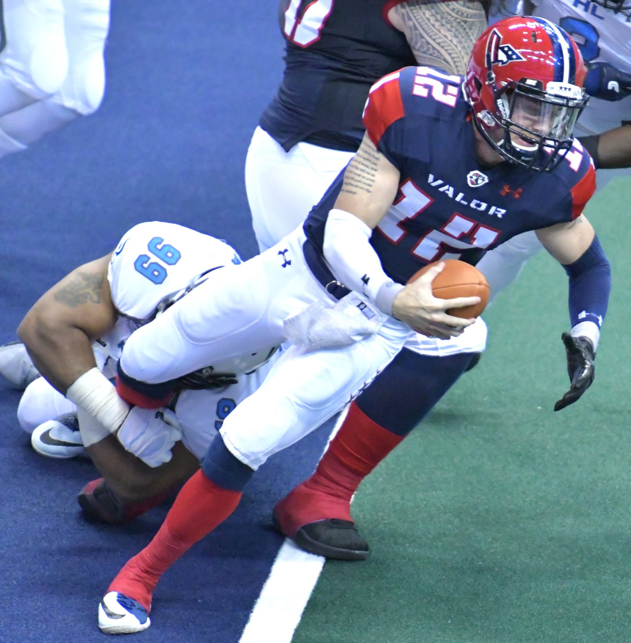 Washington Valor quarterback Sean Brackett is tackled by Philadelphia Soul defensive lineman Justin Lawrence during Philadelphia's 48-47 win at Verizon Center in D.C. on May 27. (John E. De Freitas/The Washington Informer)
