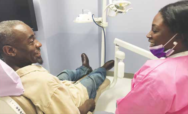 Relaxed and excited about dental care, Terry Boone talks with a Community of Hope dental team member at the Conway Health and Resource Center in Bellevue.