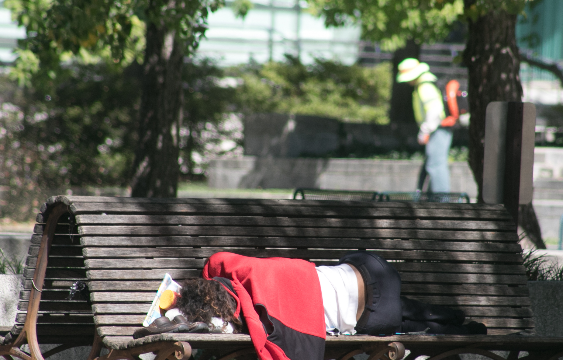 A homeless woman sleeps on a bench in front of the Canadian Embassy. (Shevry Lassiter/The Washington Informer)
