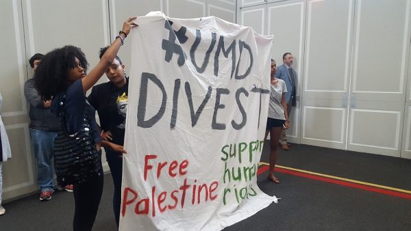 University of Maryland students and an alumnus hold a large sign, "#UMD Divest. Free Palestine, support human rights," during an Aug. 31 conversation on race, politics and reconciliation on the College Park campus. (William J. Ford/The Washington Informer)
