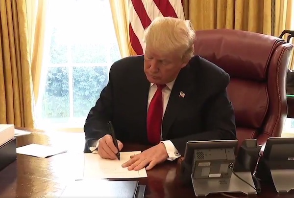 President Donald Trump signs a $1.5 trillion tax-cut bill into law at the White House on Dec. 22.