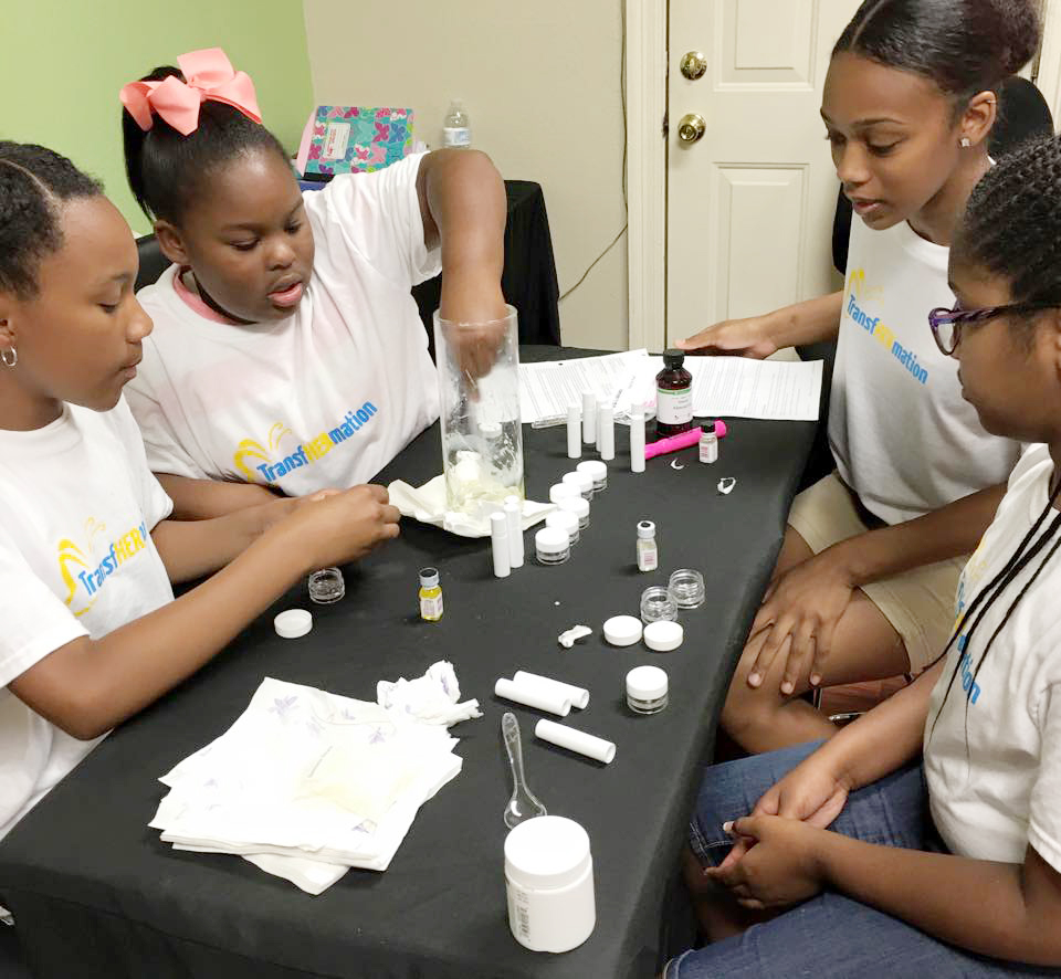 Young girls work on a business project during a TransfHERmation session. (Quintana Ricks)