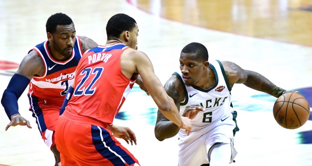 Milwaukee Bucks guard Eric Bledsoe tries to dribble around Washington Wizards forward Otto Porter Jr. (22) and guard John Wall in the third quarter of Milwaukee's 104-95 win at Capital One Arena in D.C. on Jan. 15. (John De Freitas/The Washington Informer)