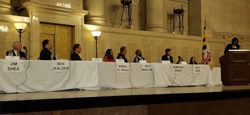 The candidates for Maryland's 2018 Democratic gubernatorial primary listen as former candidate Maya Rockeymoore Cummings (at podium) speaks during a candidates' forum at the Baltimore War Memorial on Feb. 24. (William J. Ford/The Washington Informer)