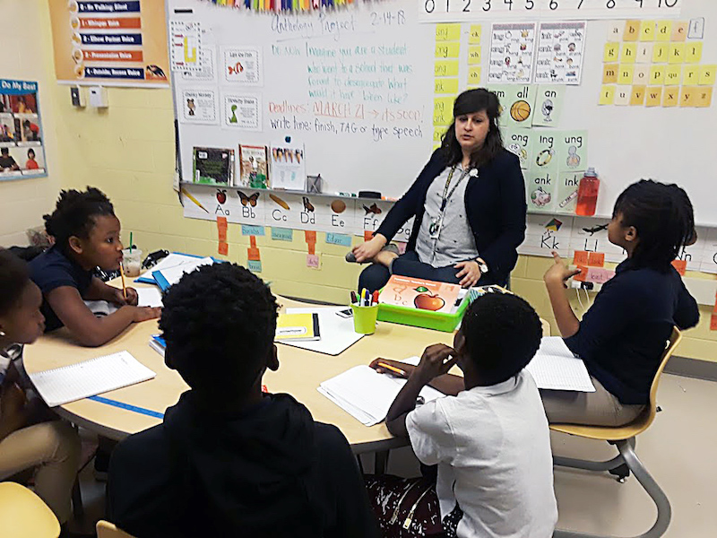 Sarah Baraba, a teacher adviser for Ketcham Elementary School's Anthology Club, coaches student members during one of their Wednesday meetings. (Dorothy Rowley/The Washington Informer)