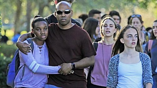 Students and parents leave at Marjory Stoneman Douglas High School in Parkland, Florida, after a gunman opened fire on the campus on Feb. 14. (Al Diaz/Miami Herald)
