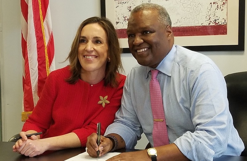 Prince George's County Executive Rushern L. Baker III signs documents to officially declare his candidacy for Maryland governor on Feb. 20, alongside running mate Elizabeth Embry. (William J. Ford/The Washington Informer)