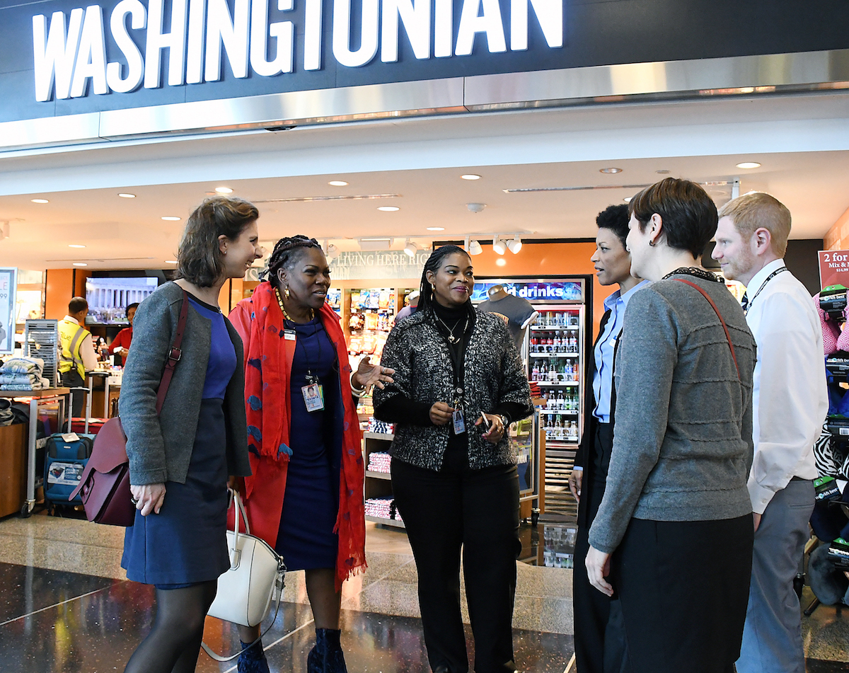 Juanita "BZB" Britton (second from left), partner and senior vice president of Paradies-BZB, DC, LLC, along with Nivlem Dickens (third from left), general manager of the Washingtonian at Ronald Reagan Washington National Airport in D.C., speak about their business at the airport with a group from France on Feb. 27. (Roy Lewis/The Washington Informer)