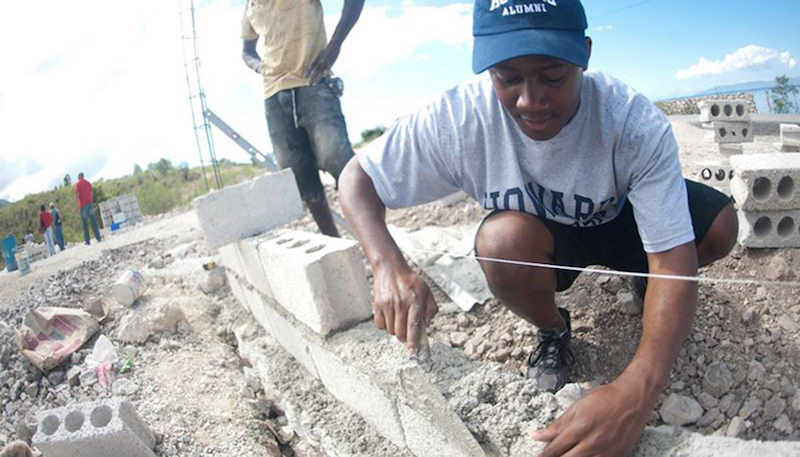 Ivon Alcime, a graduate communications major, helps build a cement wall at the School of Good Samaritans as part of a previous Alternative Spring Break in Haiti after the country was struck by an earthquake that devastated much of the island. (Justin D. Knight/Howard University)