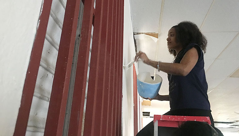 Raisa Dorsaindville, 20, paints a wall inside La Hermosa Church in downtown Arecibo, Puerto Rico. (Tatyana Hopkins/NNPA)