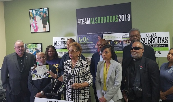 Former Maryland state Sen. Gloria Lawlah holds campaign literature from a super PAC that accuses Prince George's County State's Attorney and county executive hopeful Angela Alsobrooks (in gray and yellow) of fostering a pay-to-play culture with developers during a May 16 press conference at Alsobrooks' campaign headquarters in Largo. (William J. Ford/The Washington Informer)
