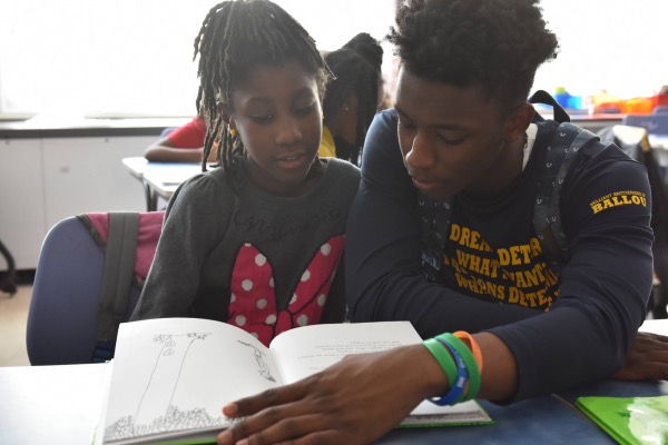The "Reach Incorporated" program aims to develop confident elementary school readers via tutoring by high school students. (Courtesy of DCPS)
