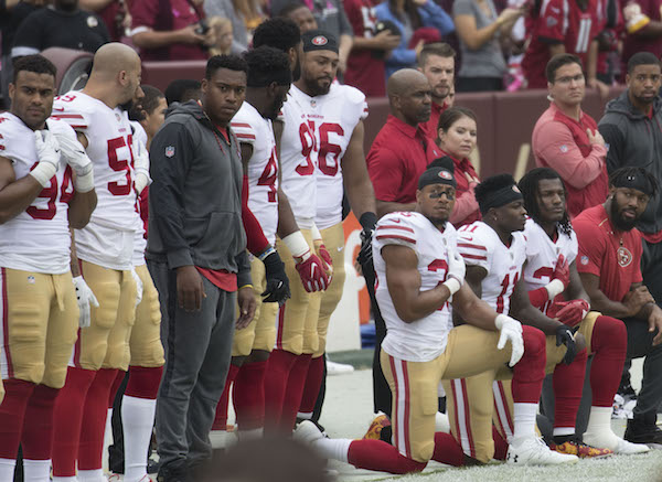 **FILE** Members of the San Francisco 49ers, including safety Eric Reid (35), kneel during the national anthem before a game against the Washington Redskins at FedEx Field in Landover, Maryland, on Oct. 15, 2017. (Keith Allison via Wikimedia Commons)