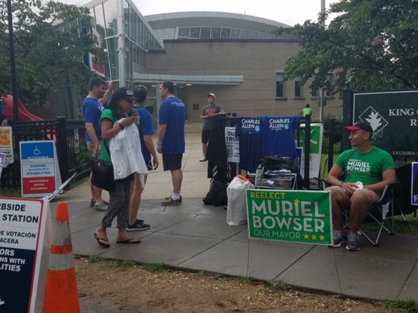 Volunteers for D.C. Mayor Muriel Bowser and city Councilman Charles Allen wait to speak with voters outside King Greenleaf Recreation Center in Southwest during the city’s primary election on June 19. (William J. Ford/The Washington Informer)