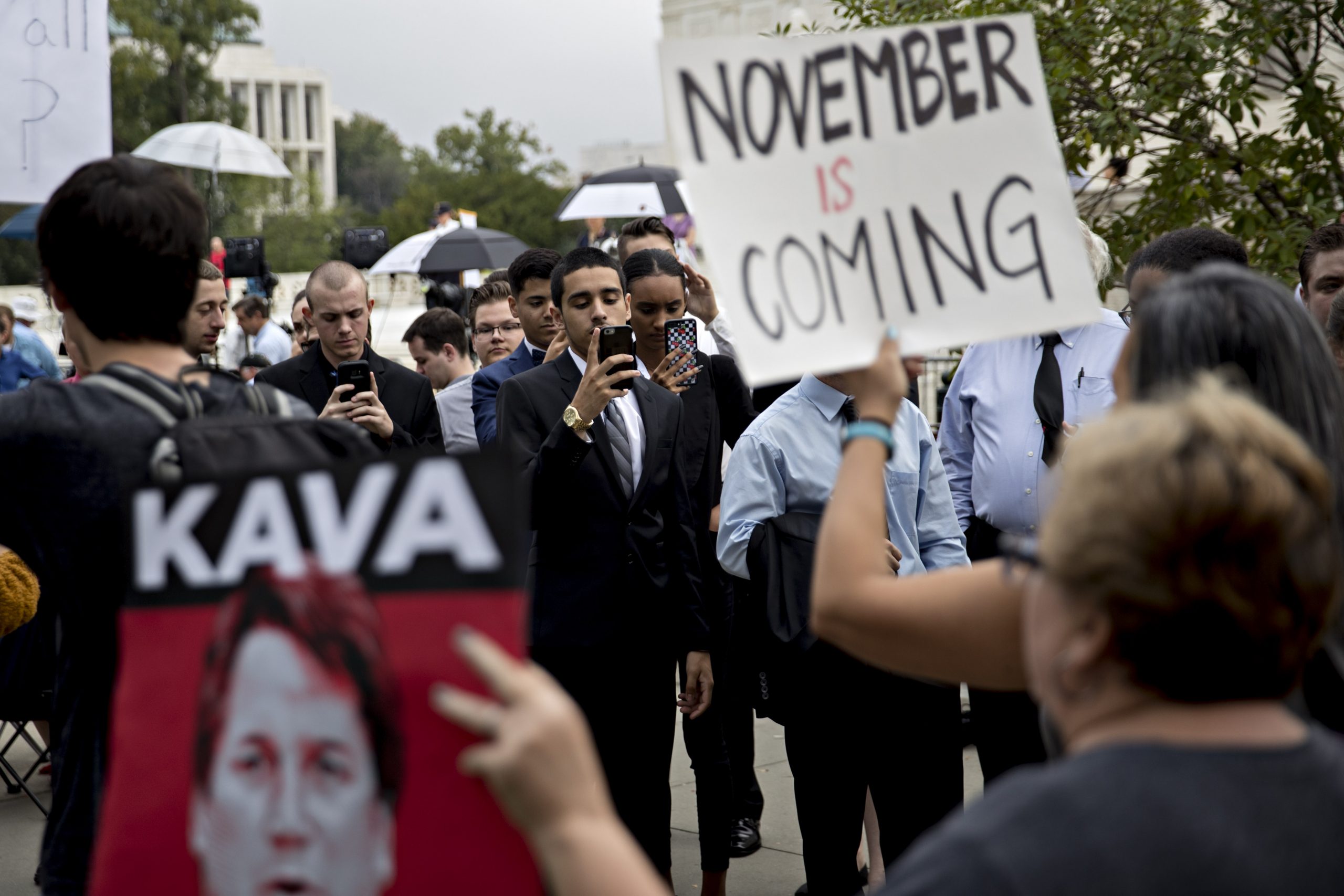 Visitors waiting in line take photographs of demonstrators outside the U.S. Supreme Court in Washington, D.C., U.S., on Tuesday, Oct. 9, 2018. Brett Kavanaugh will be at the end of the Supreme Court's bench when he hears his first argument as a justice today. He'll do so even as controversy continues to swirl over his selection by President Donald Trump and the sexual assault allegations that almost derailed it. (Andrew Harrer/Bloomberg via Getty Images)