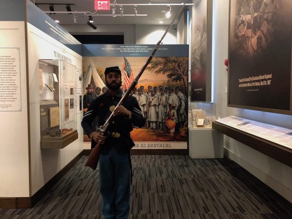 Marquett Awa Milton, the museum's interpreter, poses for a photo. (Photo by Daja E. Henry)
