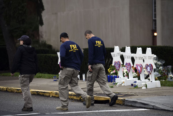 Members of the FBI walk past a memorial outside the Tree of Life synagogue after a shooting there left 11 people dead in the Squirrel Hill neighborhood of Pittsburgh on October 27. (Photo by Brendan SMIALOWSKI/AFP/Getty Images)