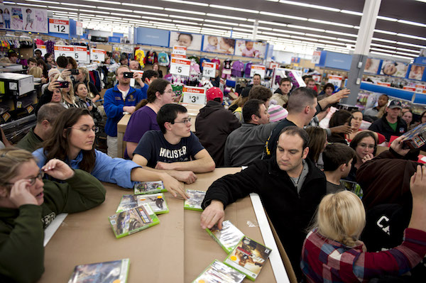 **FILE** Shoppers stand on the sidelines of a crowd that has gathered following the release of specially priced video games at a Black Friday sale at a Wal-Mart Stores Inc. store in Mentor, Ohio, U.S., on Thursday, Nov. 24, 2011. Retailers are pouring on the discounts to attract consumers grappling with 9 percent unemployment and a slower U.S. economic expansion than previously estimated. (Daniel Acker/Bloomberg via Getty Images)