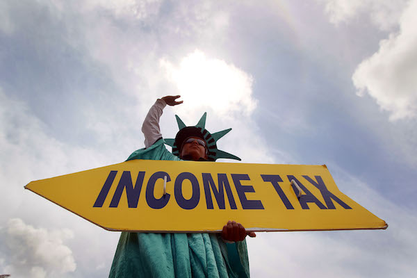 Felipe Castro holds a sign advertising a tax preparation office for people that still need help completing their taxes before the Internal Revenue Service deadline on April 14, 2010, in Miami, Florida. With only one day to go before the April 15th deadline to file taxes, accountants around the U.S. are swamped with people who waited until the last day to file. (Joe Raedle/Getty Images)