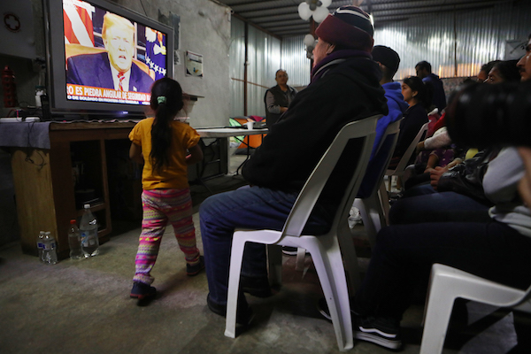 Migrants view a live televised speech by President Donald Trump on border security at a shelter for migrants on January 8, 2019 in Tijuana, Mexico. Tijuana continues to house migrants hoping to cross the border into the U.S. (Photo by Mario Tama/Getty Images)