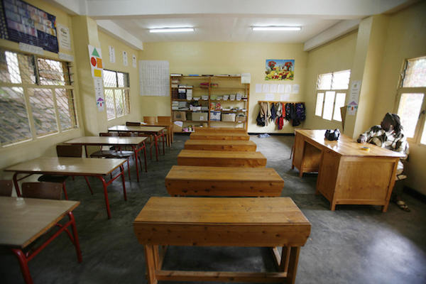 **FILE** A teacher sits at her desk inside an empty classroom of the Antoine de Saint-Exupery school in Kigali, Rwanda, on Nov. 27, 2006. (JOSE CENDON/AFP/Getty Images)
