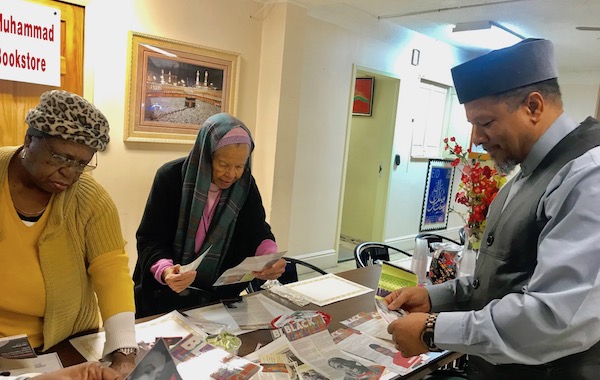 Imam Dr. Talib M. Shareef, president of the Nation’s Mosque, Masjid Muhammad and two ladies peruse The Washington Informer’s Black Facts column, which is being used to connect students with Black history. (Courtesy of Emma P. Ward)