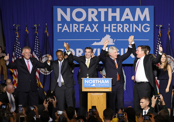**FILE** Gov.-elect Ralph Northam (C) links arms with (L-R) current Gov. Terry McAuliffe, Lt. Gov.-elect Justin Fairfax, Attorney General-elect Mark Herring, and U.S. Sen. Mark Warner (D-VA) at an election night rally November 7, 2017 in Fairfax, Virginia. Northam defeated Republican candidate Ed Gillespie. (Photo by Win McNamee/Getty Images)