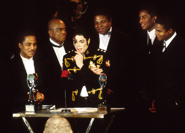 Berry Gordy Jr. of Motown Records (2nd L) with Marlon Jackson, Michael Jackson (at podium), Tito Jackson, Jermaine Jackson and Jackie Jackson of The Jackson 5, inductees (Photo by KMazur/WireImage via Getty Images)