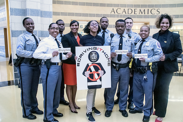 Prince George's County police officers, government officials and student representatives make a commitment to keep students safe while driving during a March 22 press conference at Oxon Hill High Schoolfor the new #DrivingItHome campaign initiative. (Shevry Lassiter/The Washington Informer)