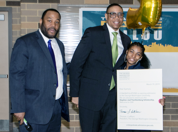 From left: Willie Jackson, Ballou Senior High School principal, and D.C. Public Schools Chancellor Lewis Ferebee announce and congratulate Syamyia Beach for being awarded a full-ride scholarship to attend George Washington University. (Shevry Lassiter/The Washington Informer)