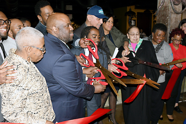 Andy Shallal, D.C. Mayor Muriel Bowser, Ward 8 Council member Trayon White and other city leaders cut the ribbon at the new Busboys and Poets location in southeast D.C, during its official opening on March 12. (Roy Lewis/The Washington Informer)