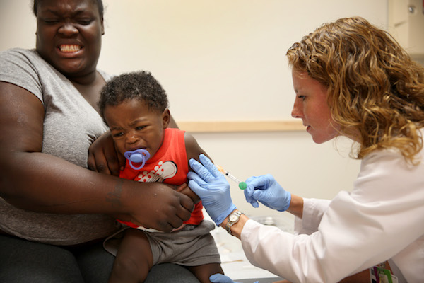 **FILE** India Ampah holds her son, Keon Lockhart, 1, as pediatrician Amanda Porro administers a measles vaccination during a visit to the Miami Children's Hospital in Miami on June 2, 2014. (Joe Raedle/Getty Images)