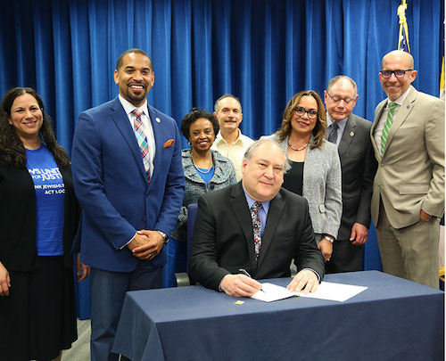 Montgomery County Executive Marc Elrich signs the Law Enforcement Trust and Transparency (LETT) Act on May 15, introduced by Council member Will Jawando (left). (Courtesy of Montgomery CountyMD.gov)
