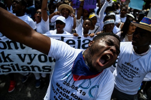 Activists and students raise placards and shout slogans during a protest against the increased number of rapes and violence against women, May 26, 2019 in Port-au-Prince.