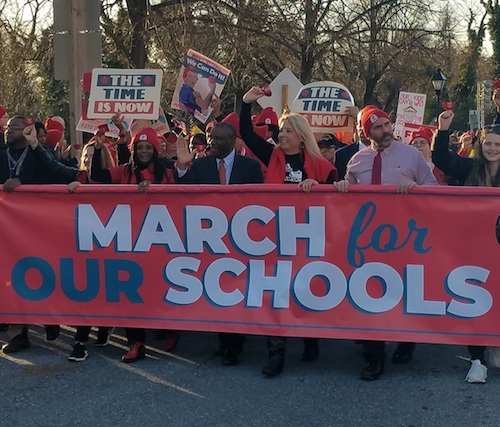 **FILE** Prince George's County school board Chairman Alvin Thornton (center in black suit) helps hold a banner during the March for Our Schools rally in Annapolis on March 11, 2019. (William J. Ford/The Washington Informer)