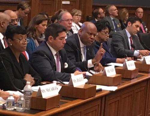 After hours of testimony before the House Finance Committee's Subcommittee on Housing, Community Development and Insurance, witnesses raise their hands in response to a question on whether homeownership discrimination against Blacks continues today. Seated left to right are: Alanna McCargo, vice president for Housing Finance Policy, Urban Institute; Nikitra Bailey, executive vice president, Center for Responsible Lending; Joseph Nery, president, National Association of Hispanic Real Estate Professionals; Jeff Hicks, president/CEO; National Association of Black Real Estate Brokers (NAREB); Carmen Castro, managing housing counselor, Housing Initiative Partnership; Joanne Poole, liaison for the National Association of Realtors; and Joel Griffith, research fellow, Financial Regulations, The Heritage Foundation. (Hazel Trice Edney/Trice Edney News Wire)