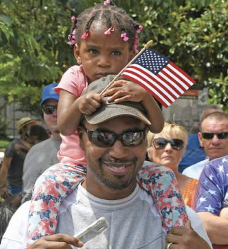 A father carries his daughter on his shoulders as they take in the sights during the 2019 Memorial Day Parade in northwest D.C. (Roy Lewis/The Washington Informer)