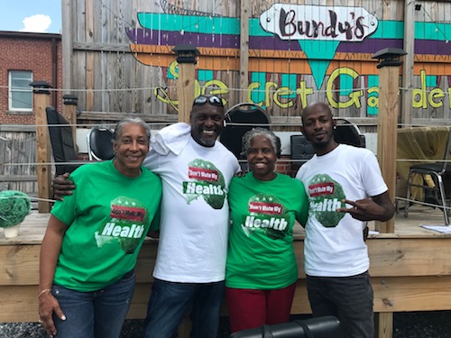 Stuart Anderson (second from left) and Ronnie Webb (right) pose with Don't Mute My Health supporters during a recent community gathering. (Courtesy photo)