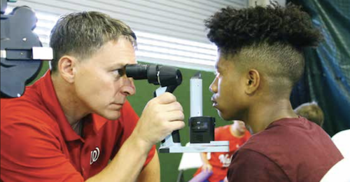 **FILE** Theodore Smith, 13, receives an eye exam from Keith Smithson, O.D., at the VSP Global Eyes of Hope mobile eye care clinic. (WI photo)