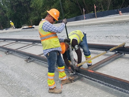 Construction workers lay down track for the Purple Line light-rail project, which will extend from New Carrollton in Prince George's County to Bethesda in Montgomery County, on Sept. 5. (William J. Ford/The Washington Informer)